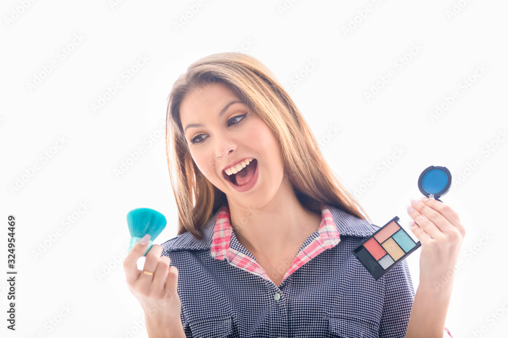 Laughing woman holding eyeshadow palette and a brush