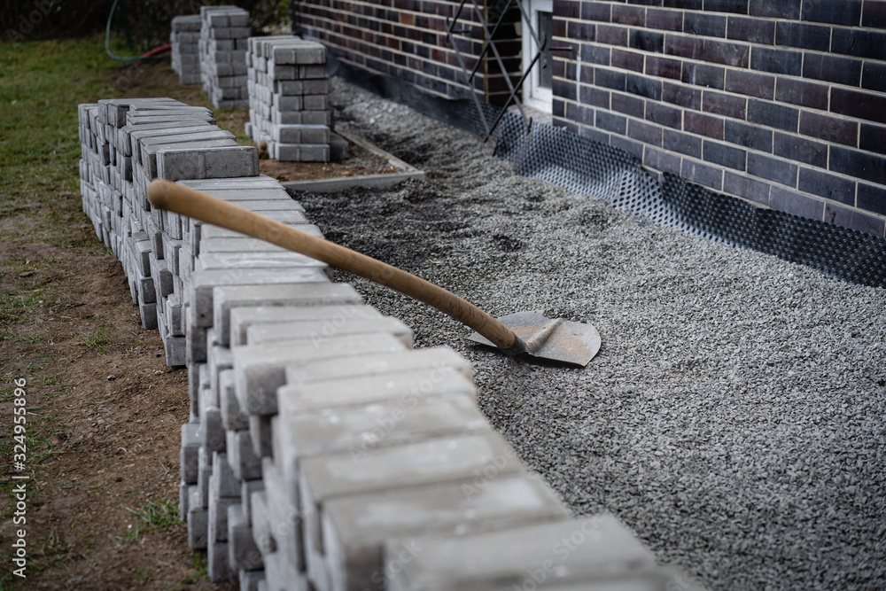 Laying gray concrete paving slabs in a house walkway. Stacks of ...