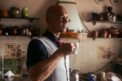 a man in the kitchen with a Cup of coffee