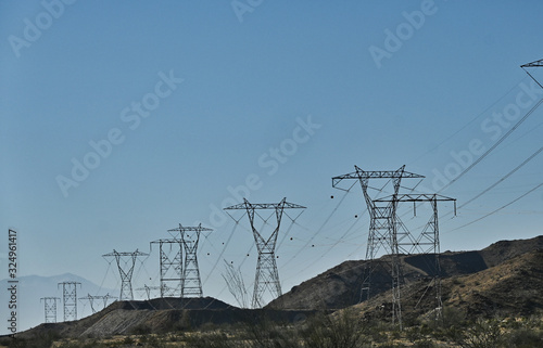Line of High Tension Line Power Transmission Towers along Desert Hills in California