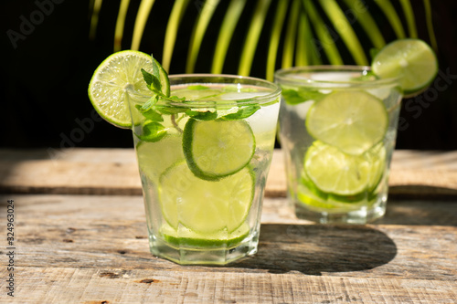 Lime and mint cocktail with rum called "mojito" on wooden background