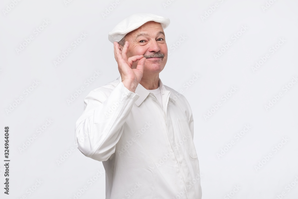 Cooking, food, profession and gesture concept. Smiling senior male chef showing sign ok. Professional male chef in white uniform gesturing excellent. Studio shot Cooking, food, profession and gesture concept. Smiling senior male chef showing sign ok. Professional male chef in white uniform gesturing excellent. Studio shot