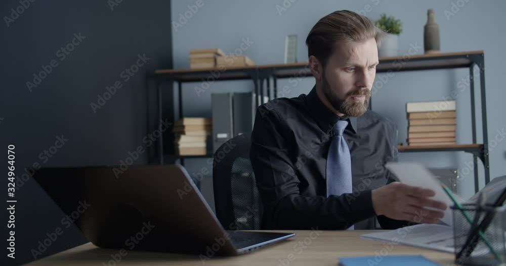 Busy middle-aged male working on laptop in office, overloaded before deadline Busy middle-aged male working on laptop in office, overloaded before deadline