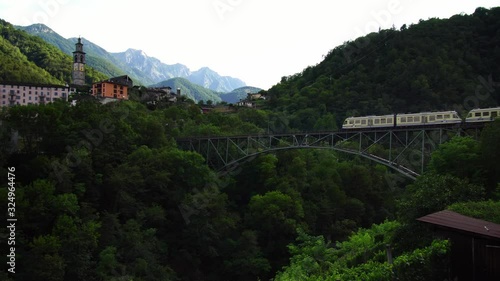 Scenic swiss train Centovalli Railway Locarno-Domodossola on bridge. Intragna village. Swiss Alps. Ticino Switzerland in summer, 4k.  photo