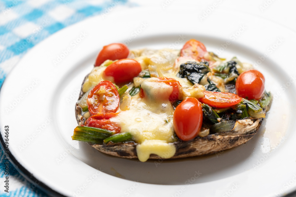 Portobello stuffed with spinach and cheese on white background Portobello stuffed with spinach and cheese on white background