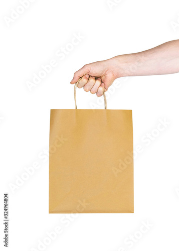 paper bag in male hand on white isolated background. hand holds yellow cardboard shopping bag. sales concept. mockup, template for text