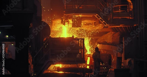 Hard work in a foundry. Metal smelting furnace in steel mill. Molten metal pouring, metallurgy, steel casting foundry. Steel manufacturing