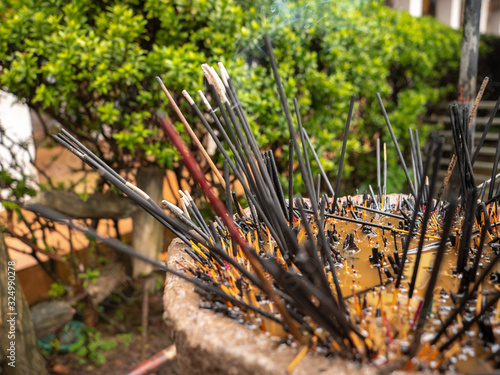 Closeup image of burning incenses in the sanctuary at buddhist temple photo