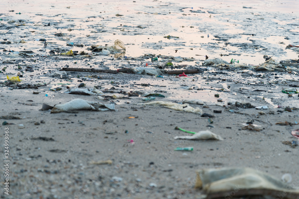 Fototapeta premium Beach pollution. Plastic bottles and other trash on sea beach
