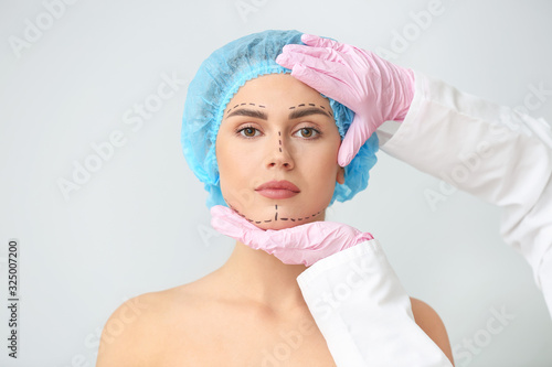 Plastic surgeon touching fa...