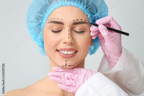 Plastic surgeon applying ma...