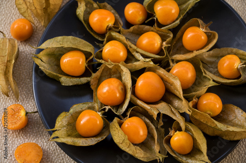 teller mit dekorativen physalisbeeren und kelchförmigen blättern photo