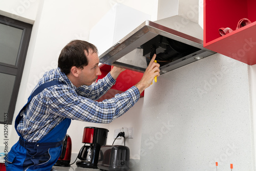 Electrician Repairing Kitchen Extractor