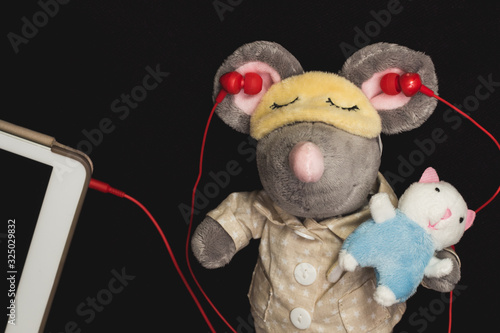 Mouse toy sleeping with red earphones