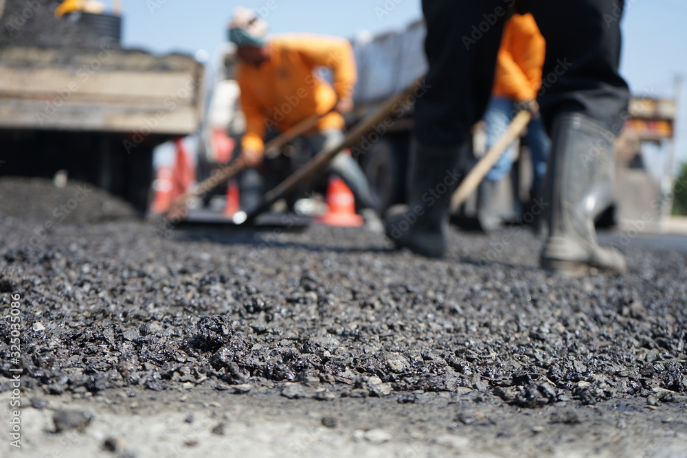 Blur image, repairing pavement mainly by manual labor