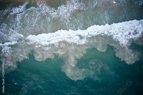 Aerial View of Waves and Azure beach with rocks. Kerala, India.