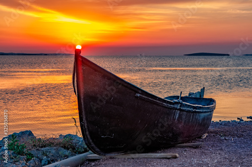 Beautiful sunrise with a boat on the lake, Razelm Razim Lake, Sarichioi, Romania