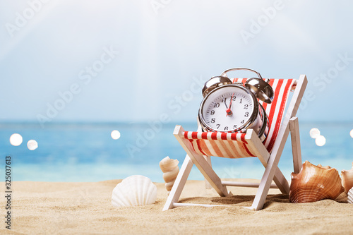 Alarm Clock On Deck Chair On Beach
