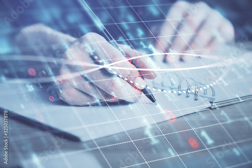 Forex graph on hand taking notes background. Concept of research. Double exposure