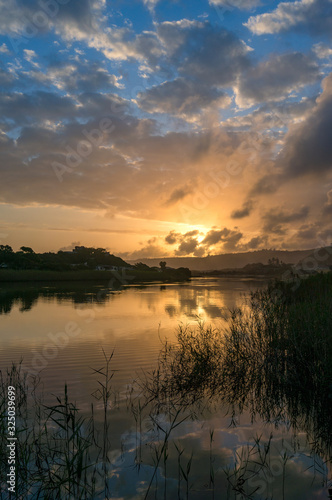 River sunset landscape with beautiful clouds and water reflection