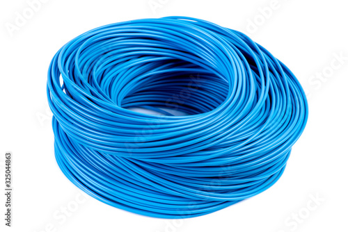 Round roll of blue electrical single core cable lying on workshop table isolated white background