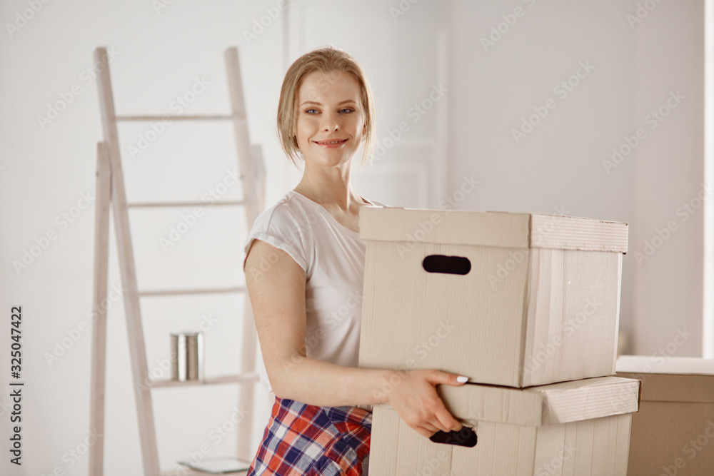 A beautiful single young woman unpacking boxes and moving into a new home A beautiful single young woman unpacking boxes and moving into a new home