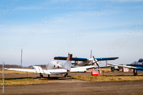A small plane stands in the parking lot of an old airfield. Wings. Airport. Airfield. Flights by plane.