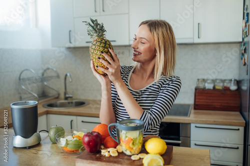 Young smiling woman with pineapple.