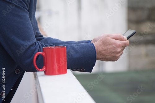 man using a tablet or e-book next to a cup of coffee
