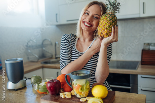 Young smiling woman with pineapple.