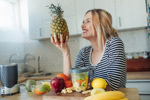 Young smiling woman with pineapple.