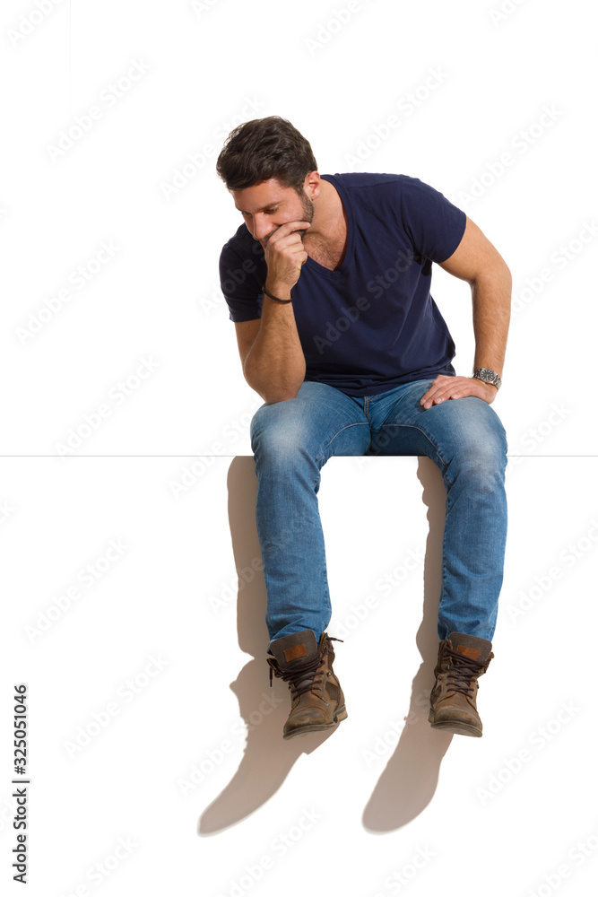 Worried Man Is Sitting On A Top Thinking And Looking Down Worried Man Is Sitting On A Top Thinking And Looking Down