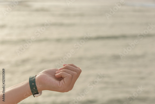 Closeup view of one female hand wearing green wristband © Andrii Oleksiienko