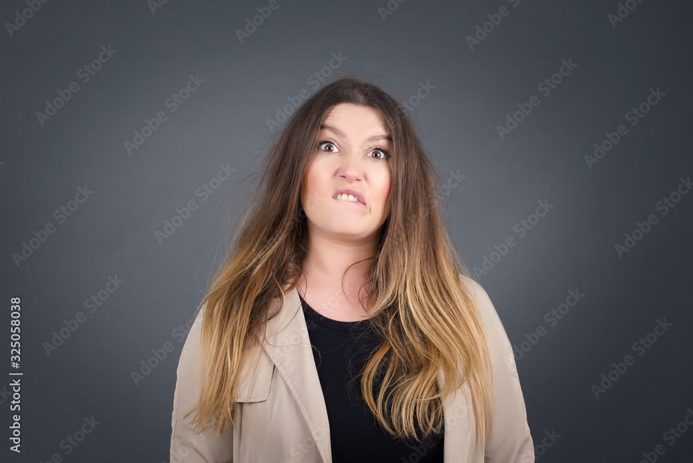 Beautiful young woman nervous and scared biting lips looking camera with impatient expression, pensiveï¿½