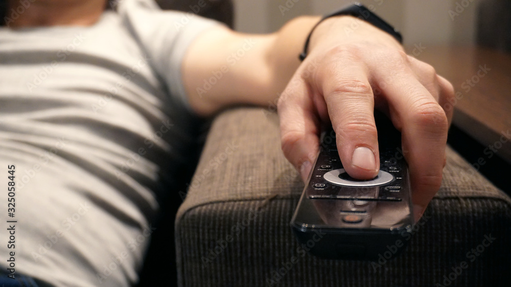 Men's hand with TV remote control. Men's hand with TV remote control.