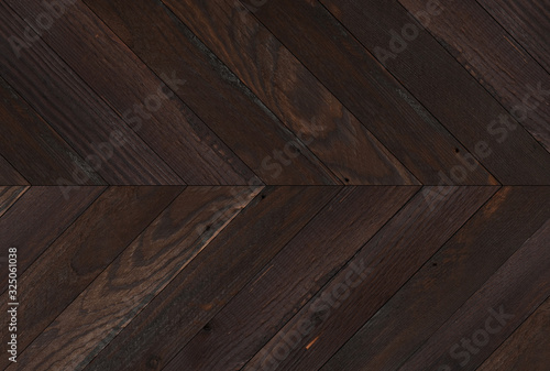 Burnt wooden boards texture for background. Brown wooden wall with herringbone pattern.