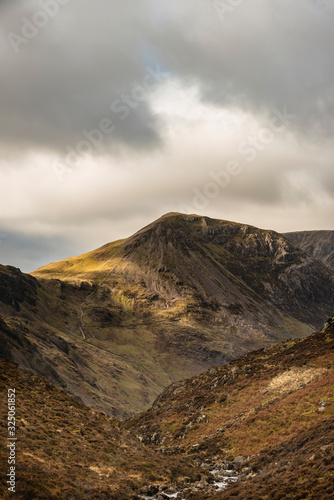 Epic Autumn Fall landscape image of mountain peaks in Lake District near Buttermere with gorgeous light across ridge