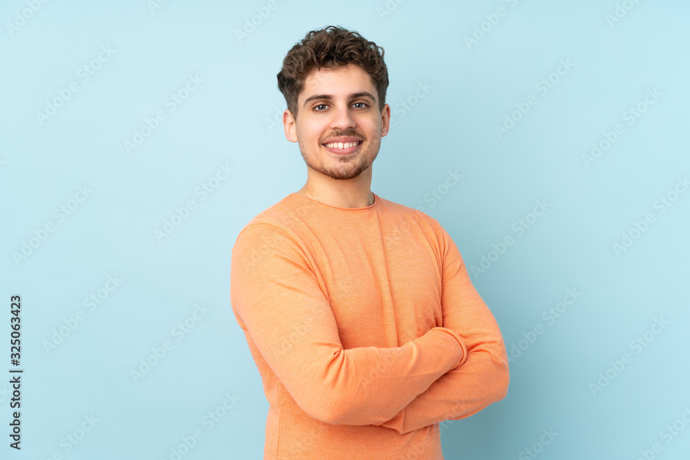 Caucasian man isolated on blue background with arms crossed and looking forward Caucasian man isolated on blue background with arms crossed and looking forward
