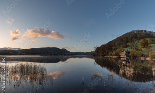 Epic vibrant sunrise Autumn Fall landscape image of Ullswater in Lake District with golden sunlight