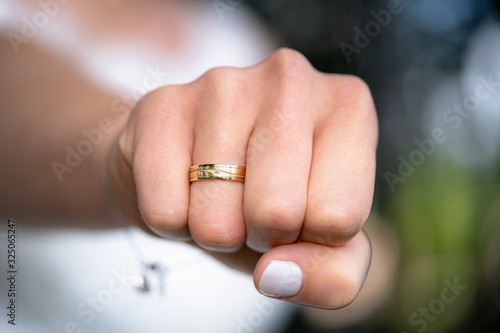 Close up of happy gold ring on woman s finger with diamond