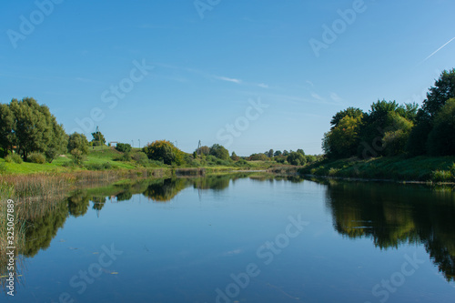 Landscape of lake and green islands and forest background. © Abinieks