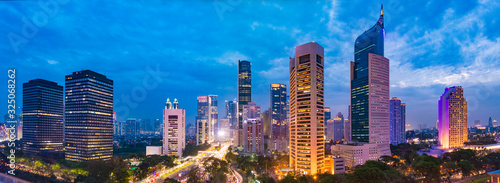 Aerial view of Jakarta's Central Business District at dusk (blue hour). Jakarta cityscape at sunset. A panorama stitched from 3 photos. Jakarta cityscape. Widescreen photo.