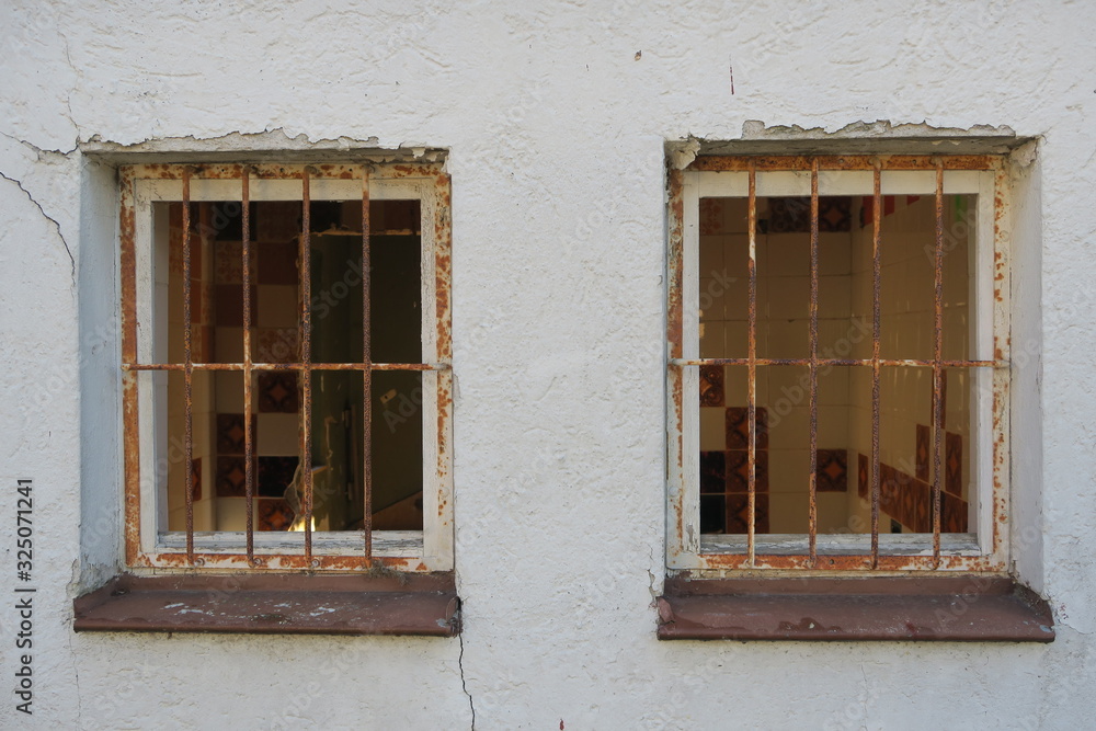 Fototapeta premium Abbruchhaus eines Vereins in Steinenbronn (Kreis Böblingen) ohne Fenster und mit verrostetem Fenstergitter. Von der Straße aus fotografiert.