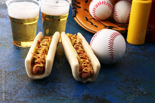 Photography Grilled hot dogs with mustard and ketchup on the table with draft beer