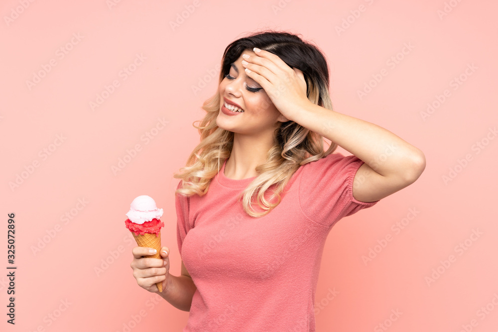 Teenager girl holding a cornet ice cream isolated on pink background has realized something and intending the solution Teenager girl holding a cornet ice cream isolated on pink background has realized something and intending the solution