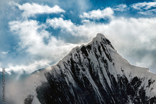 Snow Capped Peak of Kawagarbo or Kawa Karpo (also transcribed as Kawadgarbo, Khawakarpo, Moirig Kawagarbo, Kha-Kar-Po or Kawagebo Peak) under a cloudy stormy sky between Yunnan and Tibet, China photo