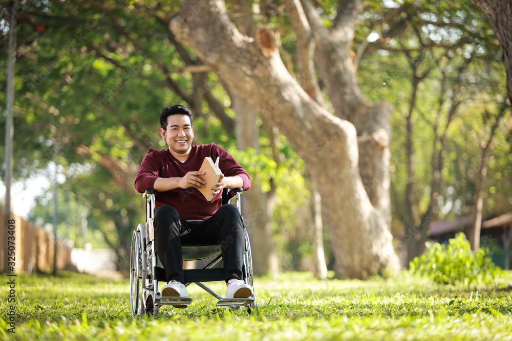 Asian Young Man sitting on the wheelchair in the park hospital Asian Young Man sitting on the wheelchair in the park hospital