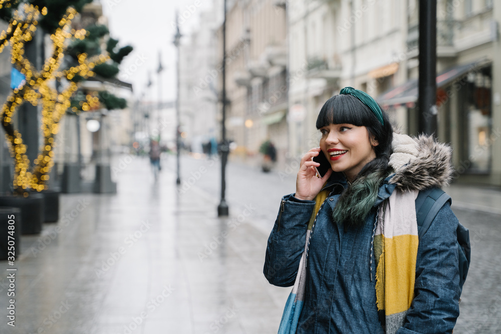 Fototapeta premium Stylish woman using smartphone in the street