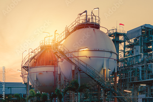 Gas storage sphere tanks in oil and gas refinery industrial plant with sunset sky background photo
