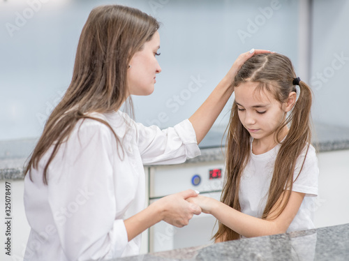 Mother calms her upset daughter while talking with her at home